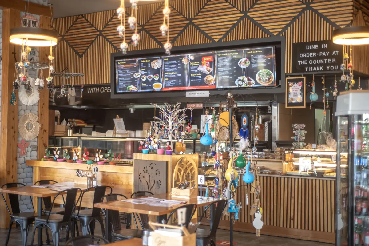 Digital menu boards above a food counter