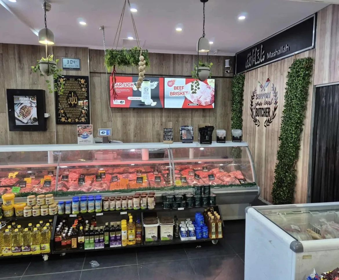 Digital screens above the meat counter at a butcher shop